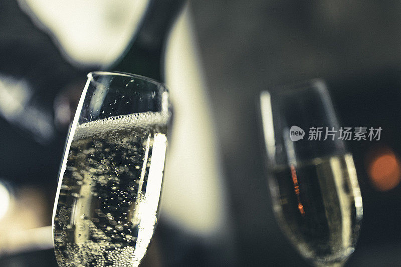 光明的日子! !背景是一瓶冰冻的起泡酒，前景是两杯。